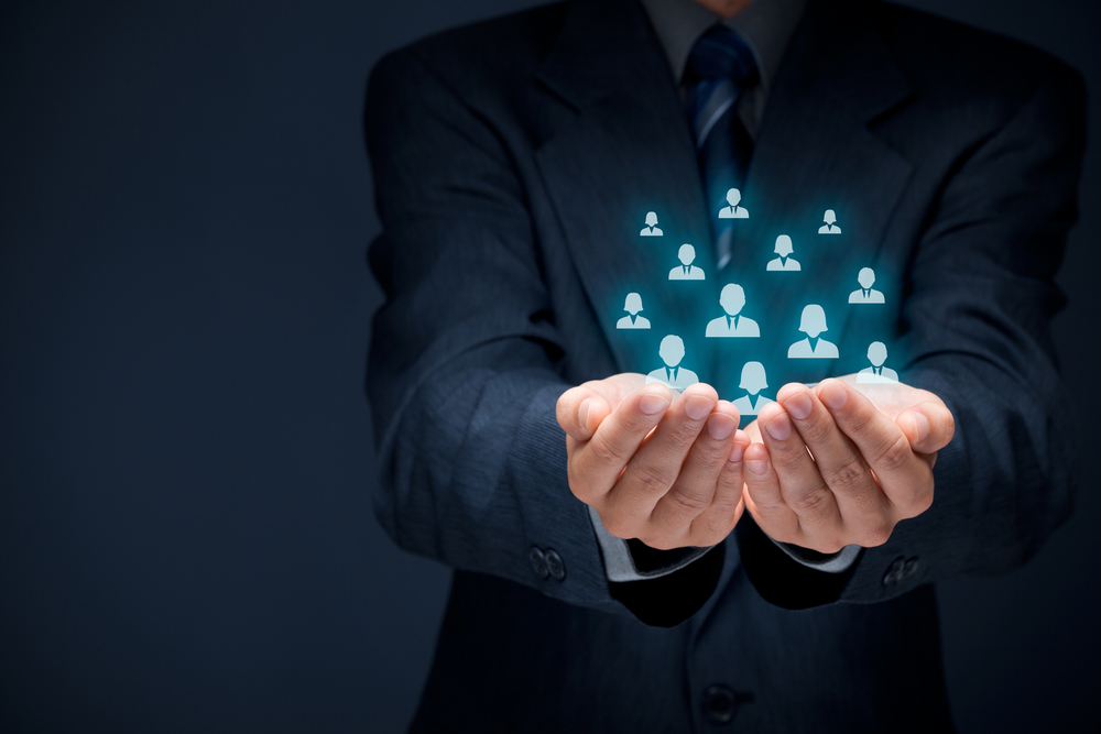 Employer with his hands cupped to hold on to team of staff