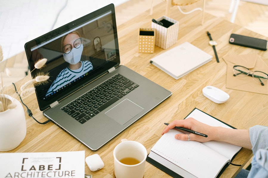 Woman on Zoom call wearing a face mask. Photo by Ivan Samkov from Pexels